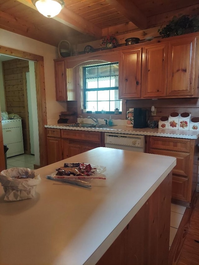 1210 Elkins Rd, Cairo, GA 39827 - kitchen with washer / dryer, white dishwasher, light countertops, a wooden ceiling with exposed beams, and brown cabinetry