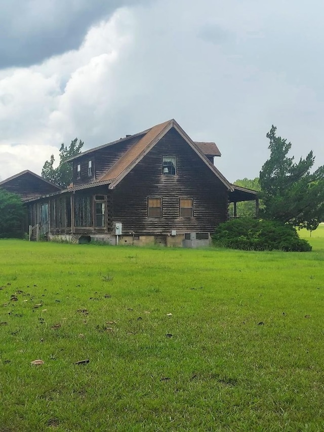 1210 Elkins Rd, Cairo, GA 39827 - rear view of house featuring a lawn and log exterior
