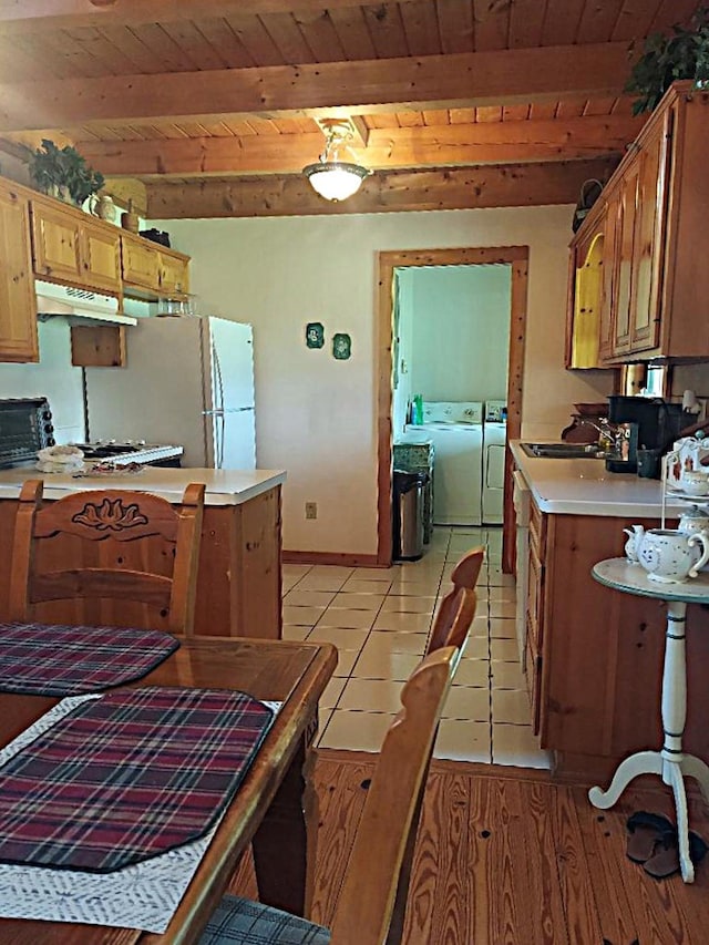 1210 Elkins Rd, Cairo, GA 39827 - kitchen with washing machine and dryer, a wooden ceiling with exposed beams, under cabinet range hood, light countertops, and light tile patterned floors
