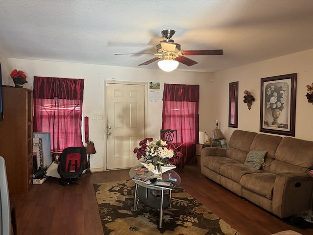 living room featuring ceiling fan, dark hardwood / wood-style flooring, and a textured ceiling