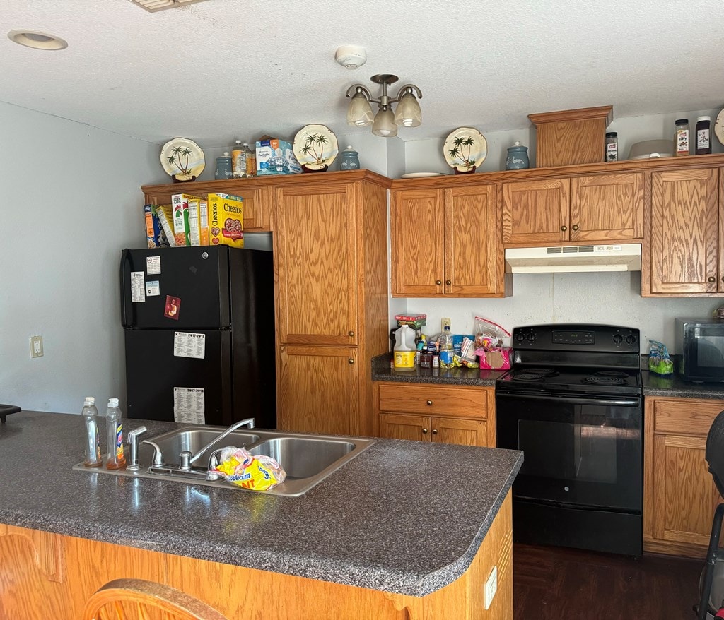 kitchen with dark hardwood / wood-style flooring, sink, black appliances, and a textured ceiling