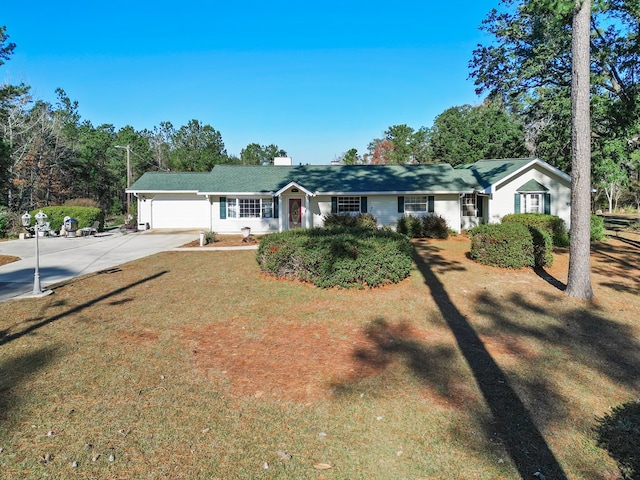 ranch-style home with a garage and a front lawn