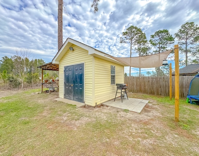 view of outbuilding with a trampoline and a lawn