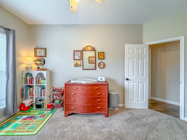 recreation room with carpet floors and a textured ceiling