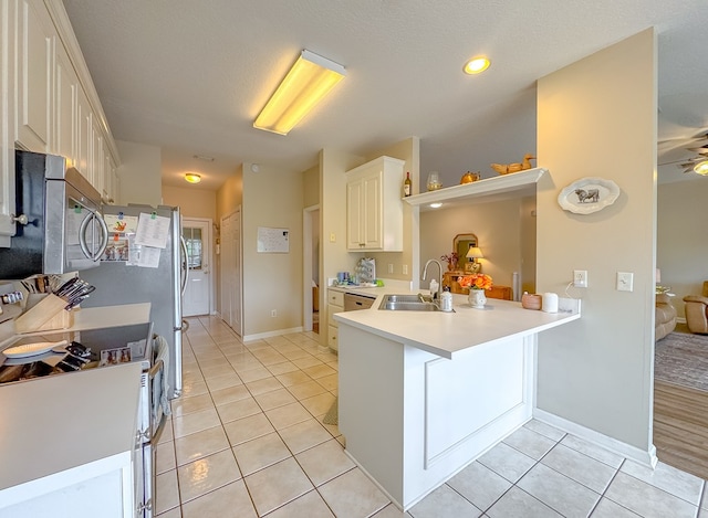 kitchen featuring light tile patterned floors, a breakfast bar, sink, electric range oven, and kitchen peninsula