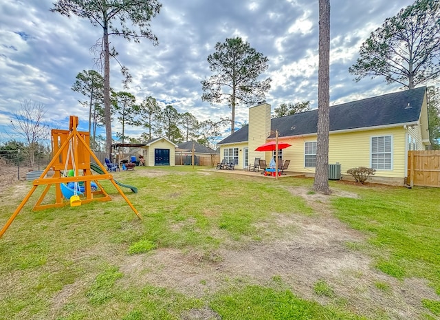 view of yard featuring an outdoor structure, a patio, a playground, and central AC unit