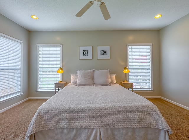 bedroom with a textured ceiling, light carpet, and ceiling fan