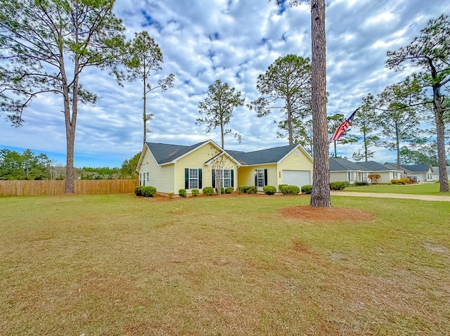 ranch-style home featuring a garage and a front lawn