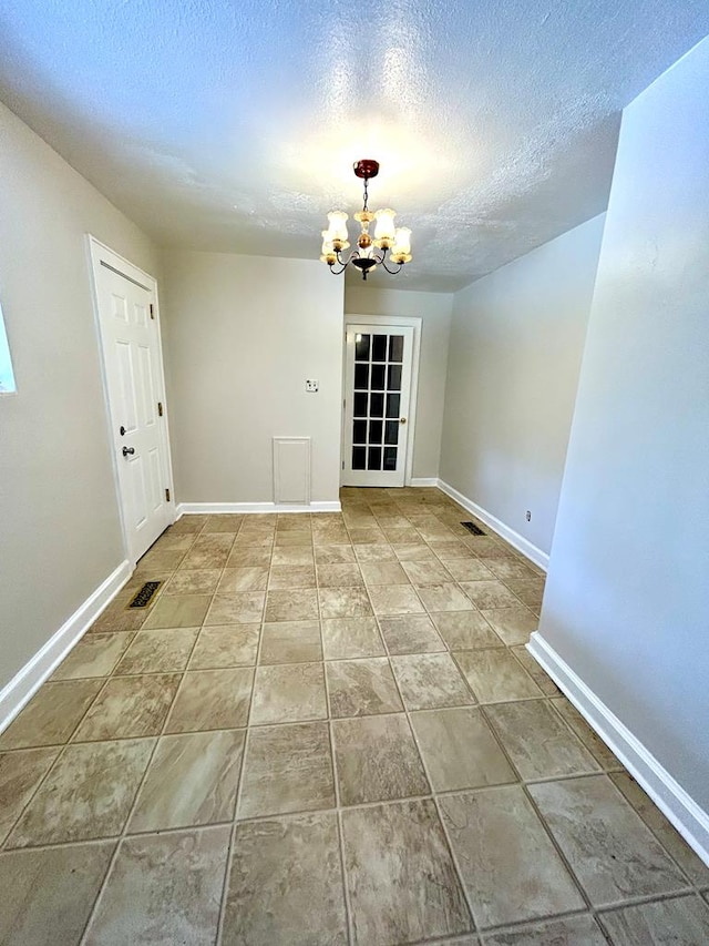 356 E Main St, Colquitt, GA 39837 - unfurnished dining area featuring a chandelier, a textured ceiling, and baseboards