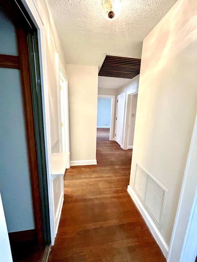 356 E Main St, Colquitt, GA 39837 - corridor featuring wood finished floors, a textured ceiling, and baseboards
