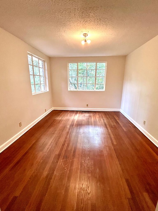 356 E Main St, Colquitt, GA 39837 - empty room featuring dark wood finished floors, baseboards, and a textured ceiling