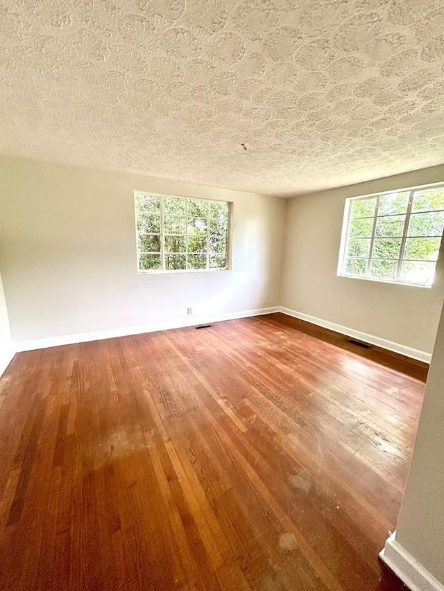 356 E Main St, Colquitt, GA 39837 - spare room with wood-type flooring, baseboards, and a textured ceiling