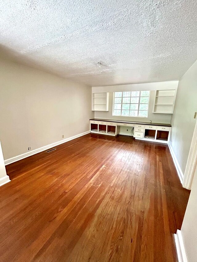 356 E Main St, Colquitt, GA 39837 - spare room featuring dark wood-style flooring, a textured ceiling, and baseboards