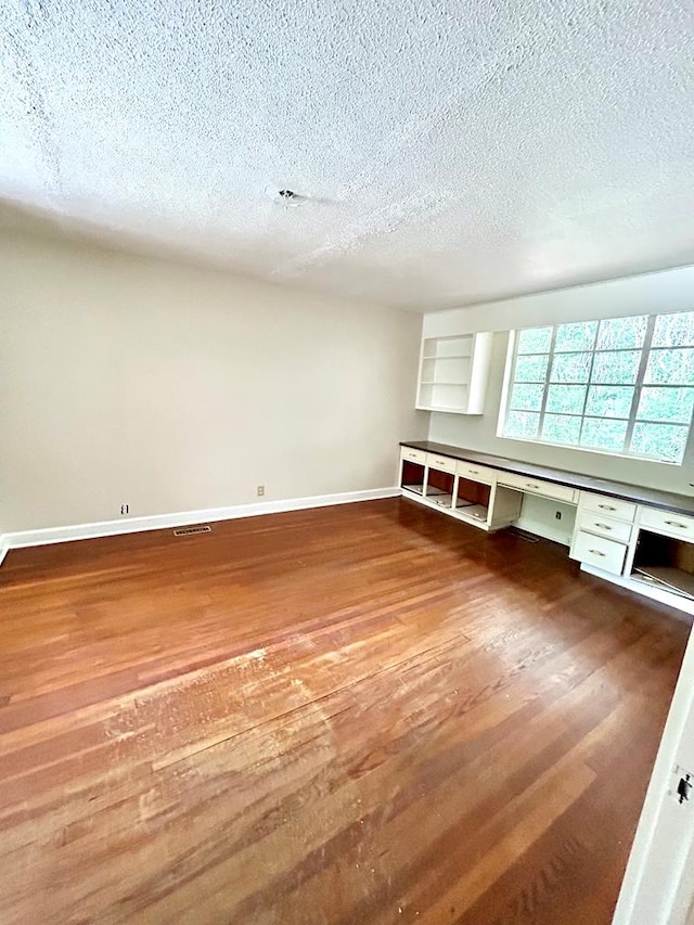 356 E Main St, Colquitt, GA 39837 - empty room with a textured ceiling, wood finished floors, and baseboards