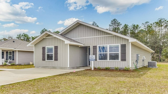 view of front of house with a front yard and central AC