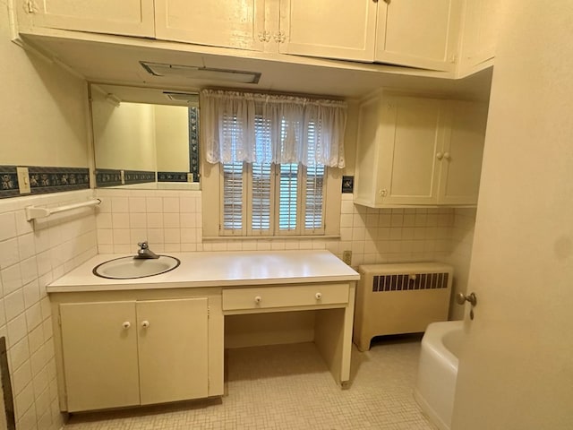 bathroom featuring tile patterned flooring, radiator heating unit, tile walls, and vanity