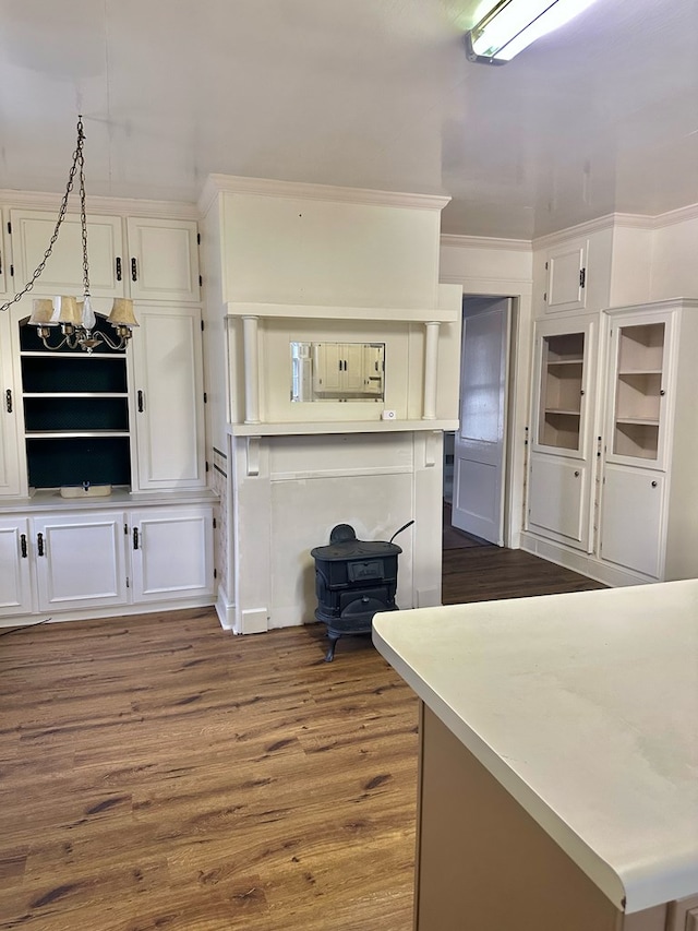 kitchen featuring white cabinetry, light countertops, dark wood-type flooring, and ornamental molding