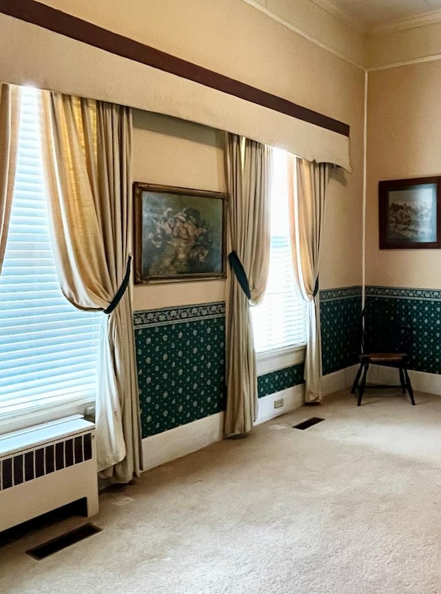 living area with carpet floors, radiator heating unit, ornamental molding, baseboards, and wallpapered walls