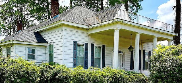 view of home's exterior with covered porch and a chimney