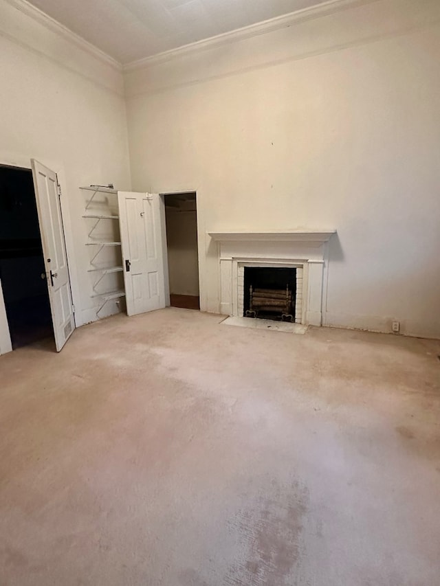 unfurnished living room featuring ornamental molding, a fireplace with flush hearth, and a towering ceiling