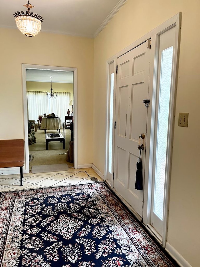 entryway with light tile patterned floors, ornamental molding, and baseboards