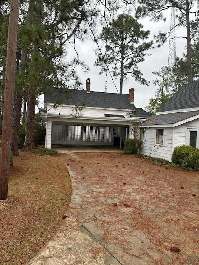 view of front of house with driveway and a chimney