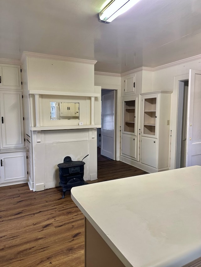 kitchen with ornamental molding, white cabinets, dark wood finished floors, and light countertops