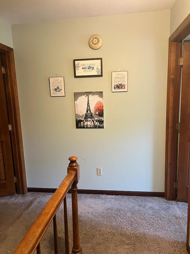 corridor with carpet flooring, an upstairs landing, and baseboards