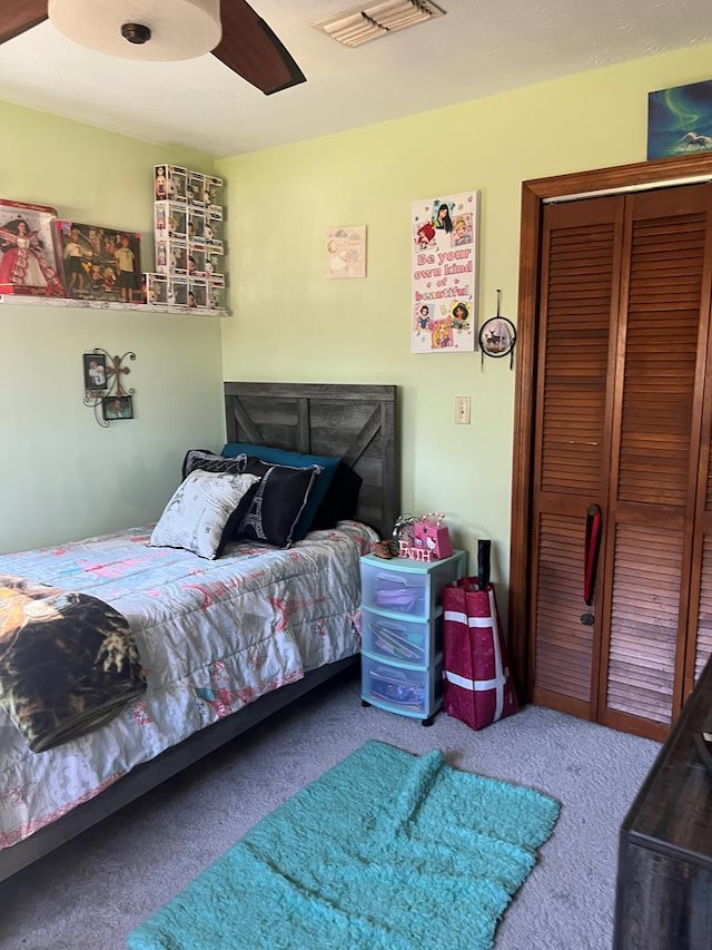 carpeted bedroom featuring visible vents, a closet, and ceiling fan