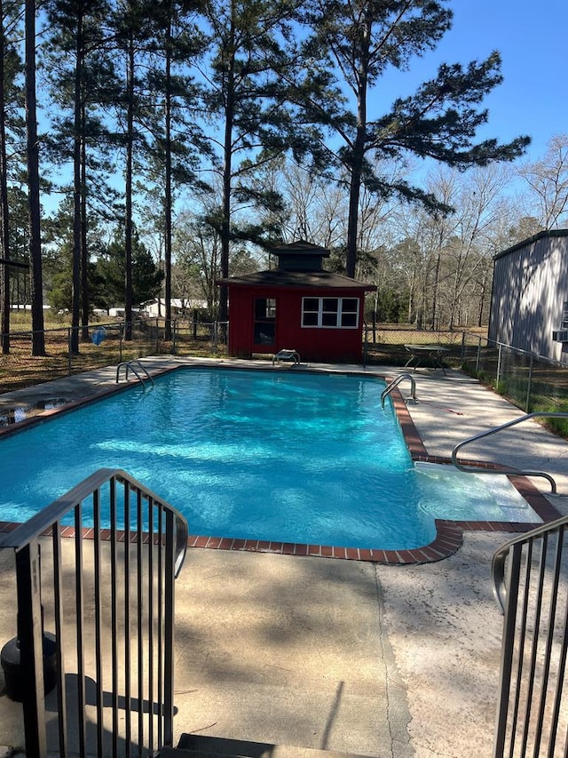 view of pool with a fenced in pool, a patio, an outdoor structure, and fence