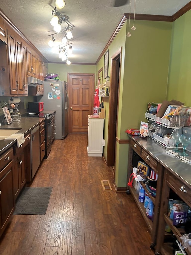 kitchen with a textured ceiling, appliances with stainless steel finishes, dark wood finished floors, and crown molding