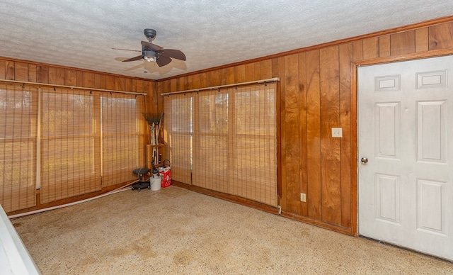 unfurnished bedroom featuring wooden walls and ceiling fan