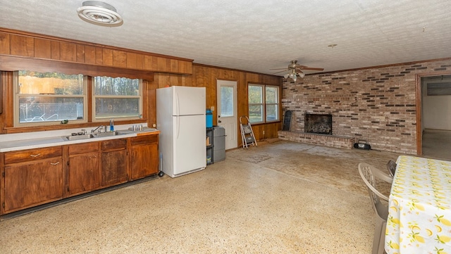 kitchen featuring sink, a textured ceiling, ceiling fan, and white fridge