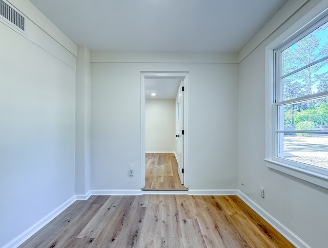 empty room featuring a healthy amount of sunlight and light hardwood / wood-style flooring