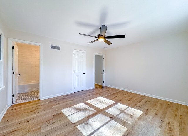 unfurnished bedroom featuring ensuite bath, a closet, ceiling fan, and light hardwood / wood-style flooring