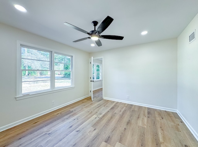 empty room with ceiling fan and light hardwood / wood-style floors