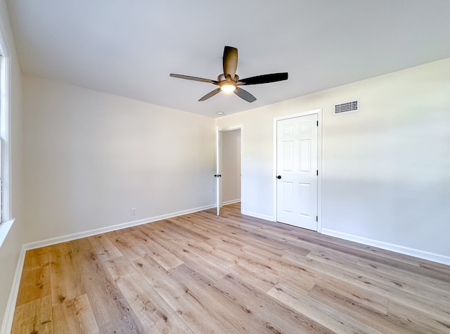 empty room with ceiling fan and light hardwood / wood-style flooring