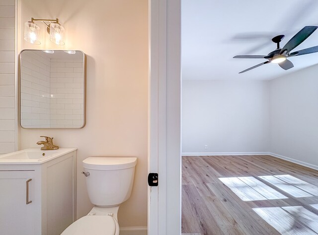 bathroom with toilet, vanity, ceiling fan, and hardwood / wood-style flooring