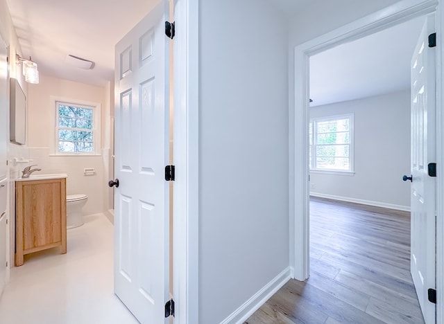 corridor featuring light hardwood / wood-style floors and sink