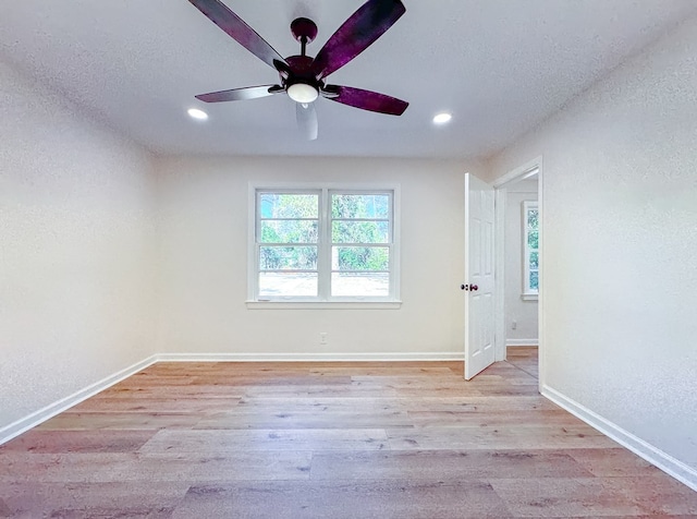 unfurnished room featuring light hardwood / wood-style floors, ceiling fan, and a textured ceiling