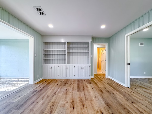 interior space featuring light wood-type flooring and wood walls