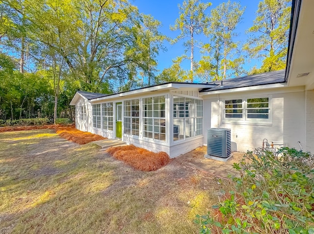 rear view of property featuring cooling unit and a sunroom