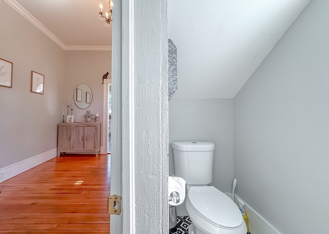 313 E Evans St, Bainbridge, GA 39817 - bathroom featuring wood finished floors, toilet, baseboards, ornamental molding, and a chandelier