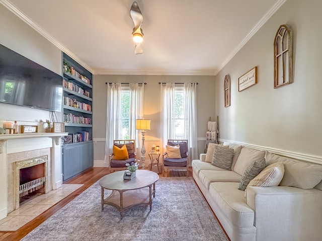 313 E Evans St, Bainbridge, GA 39817 - living room featuring wood finished floors, ornamental molding, a tile fireplace, built in features, and baseboards