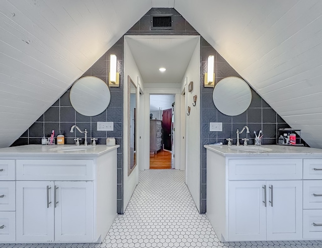313 E Evans St, Bainbridge, GA 39817 - full bathroom with tile walls, two vanities, and vaulted ceiling