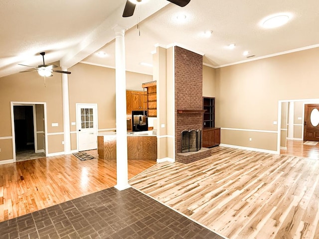 1870 SE Oakdale Rd, Cairo, GA 39828 - unfurnished living room with wood finished floors, a ceiling fan, baseboards, decorative columns, and a brick fireplace