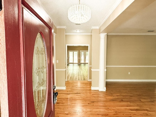 1870 SE Oakdale Rd, Cairo, GA 39828 - foyer with light wood-style flooring, a textured ceiling, decorative columns, baseboards, and a notable chandelier
