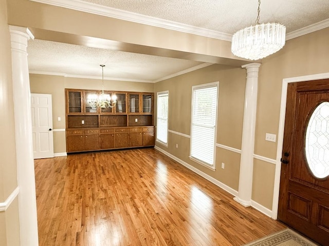 1870 SE Oakdale Rd, Cairo, GA 39828 - foyer entrance with baseboards, light wood finished floors, ornate columns, and a notable chandelier