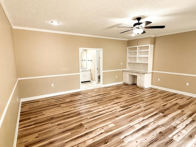 1870 SE Oakdale Rd, Cairo, GA 39828 - unfurnished living room featuring a textured ceiling, built in study area, ceiling fan, light wood finished floors, and ornamental molding