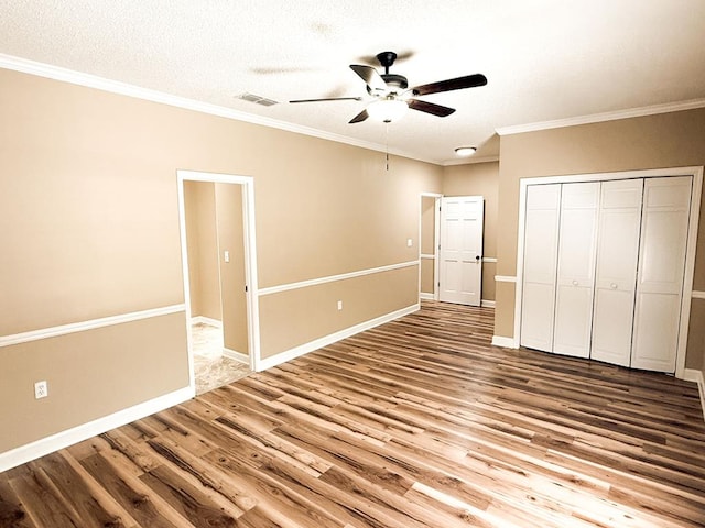 1870 SE Oakdale Rd, Cairo, GA 39828 - unfurnished bedroom with crown molding, wood finished floors, a closet, baseboards, and visible vents